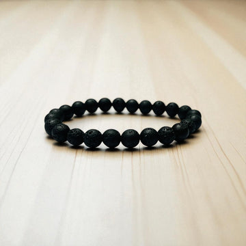 Natural lava stone bracelet on a wooden surface, cleansing and charging a crystal bracelet safely