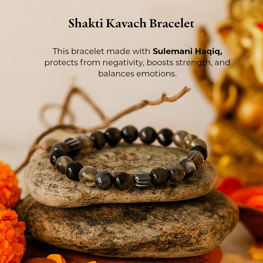 Sulemani Hakik Bracelet (Shakti Kavach) on stacked stones with marigold flowers, black agate beads